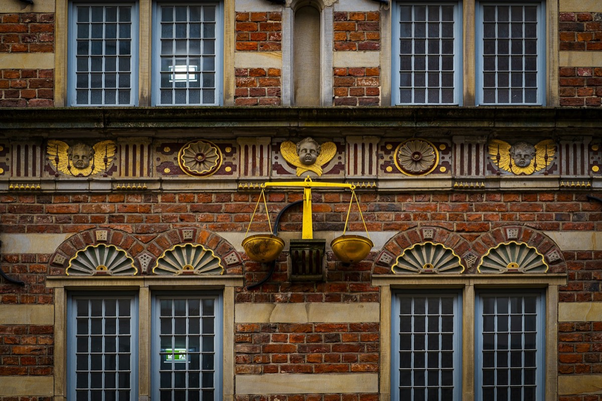 A brick building with a scale on the front of it