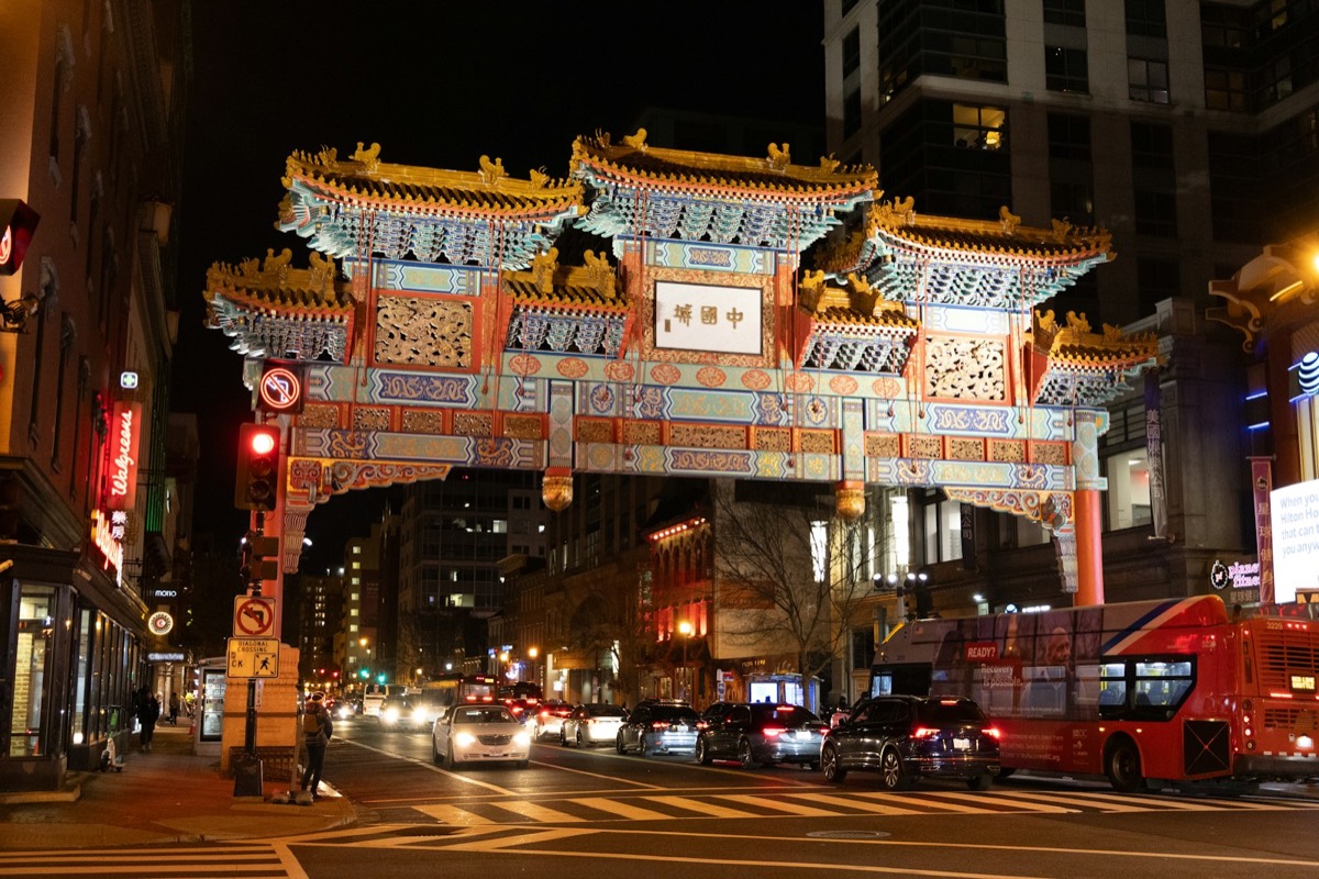 A city street filled with traffic under a tall building