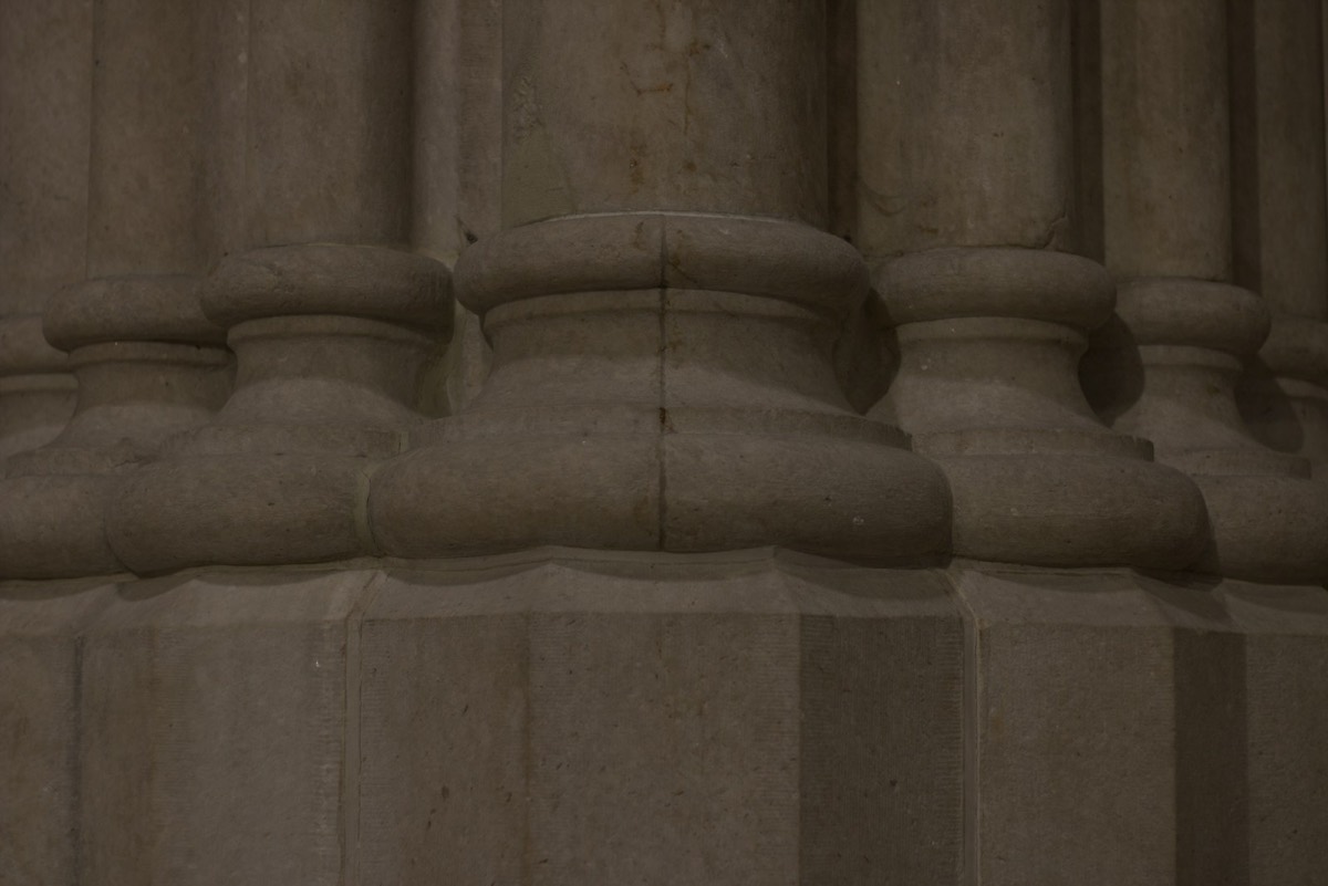 A close up of a stone column with a clock on it