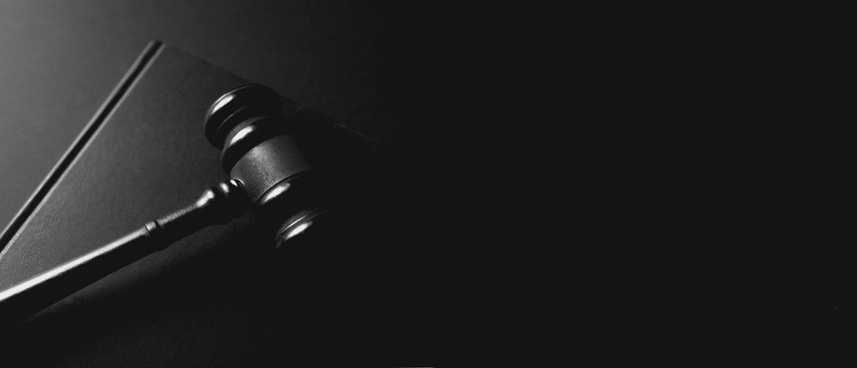 A gavel rests on a dark background