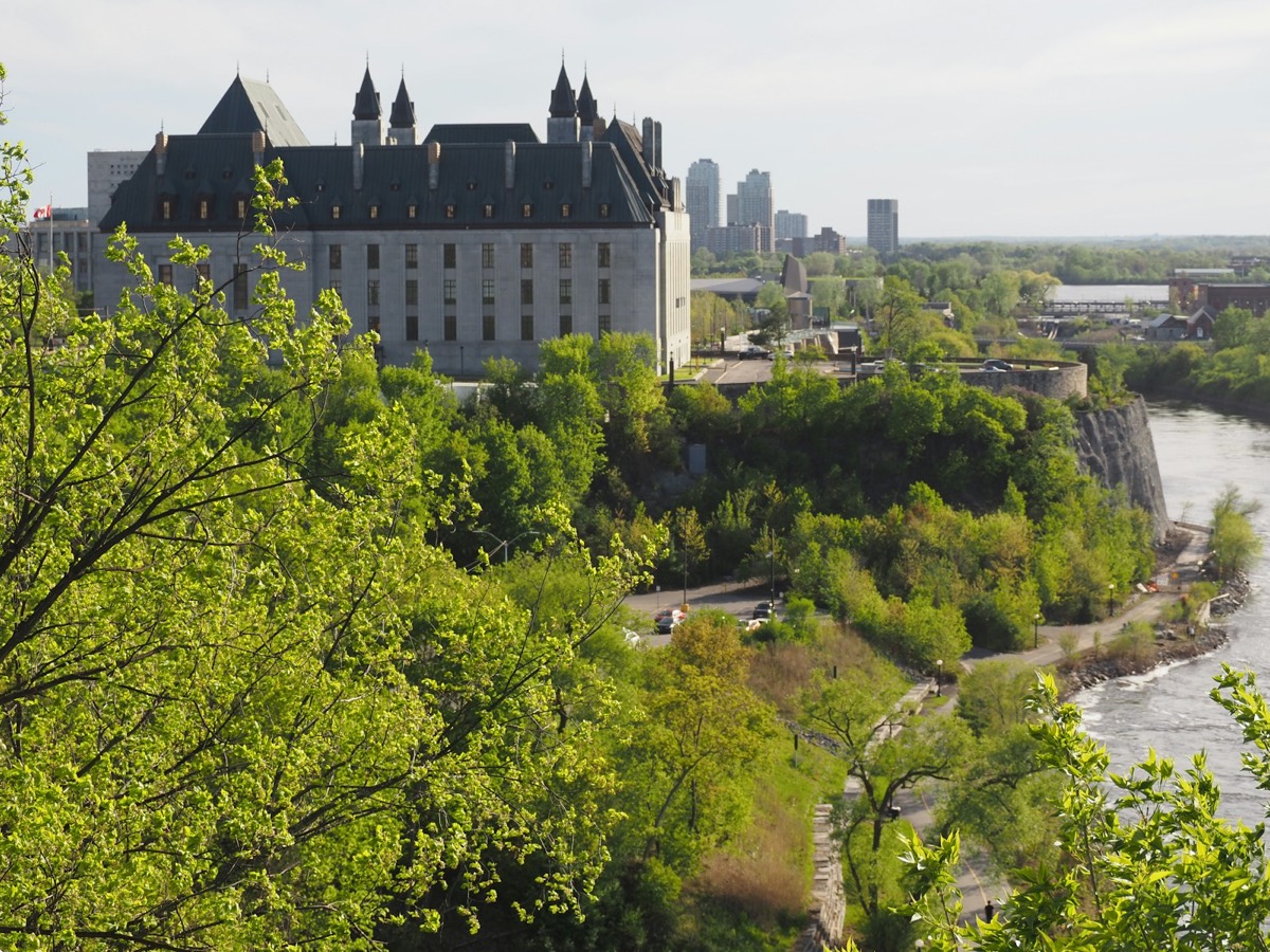 A large building overlooking a river with a city skyline