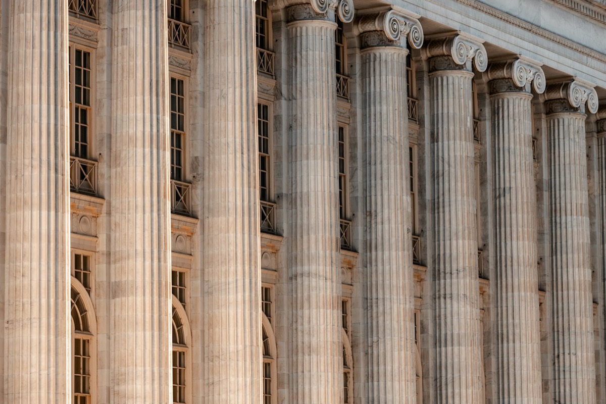 A large building with columns and a clock on the front of it