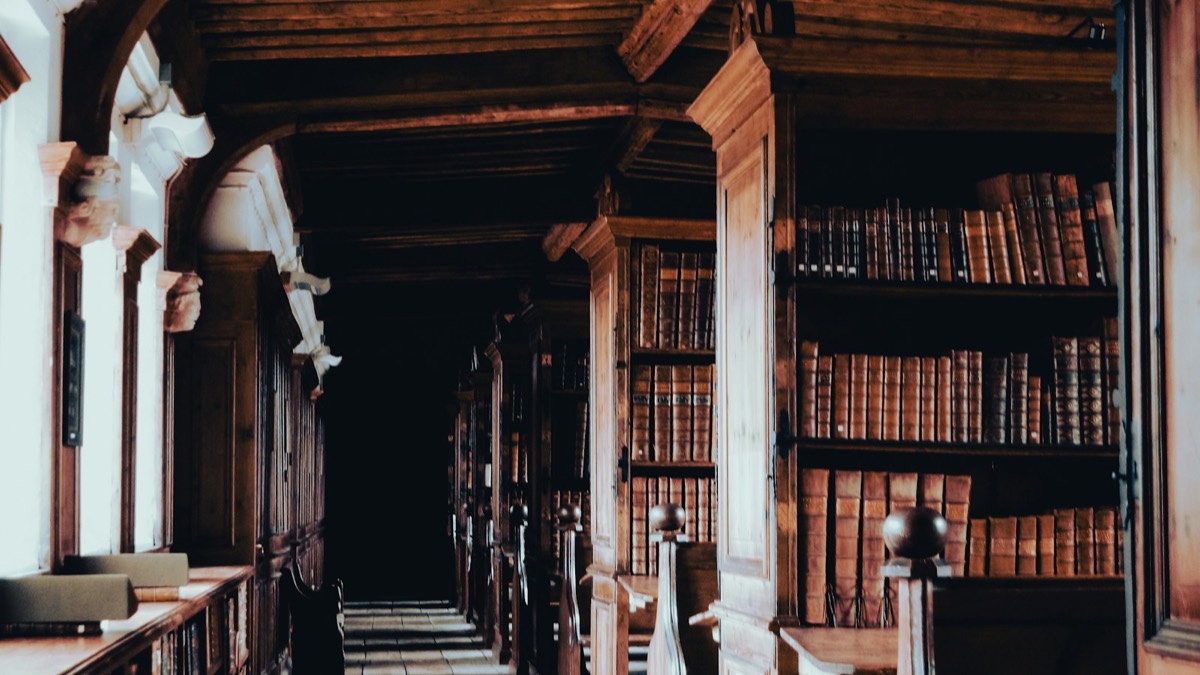 a long row of wooden bookshelves in a library