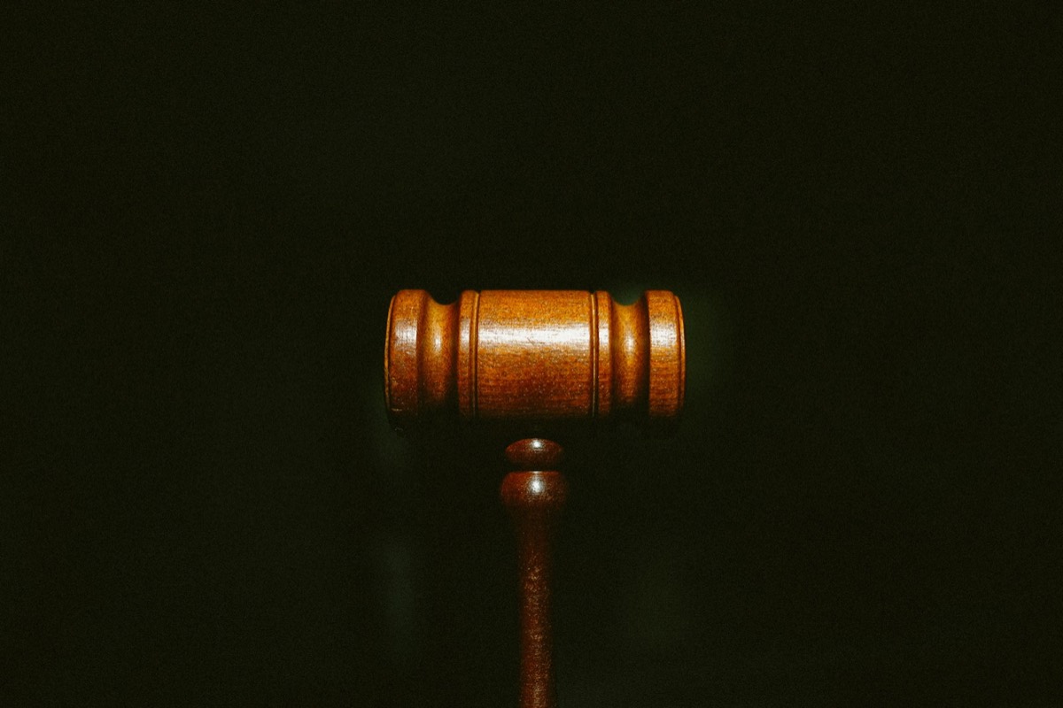 A polished wooden judge gavel centered against a dark background