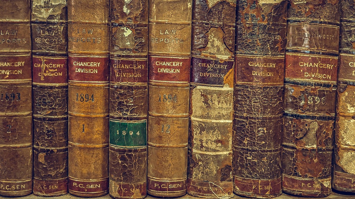 A row of very old, worn-out books on a shelf