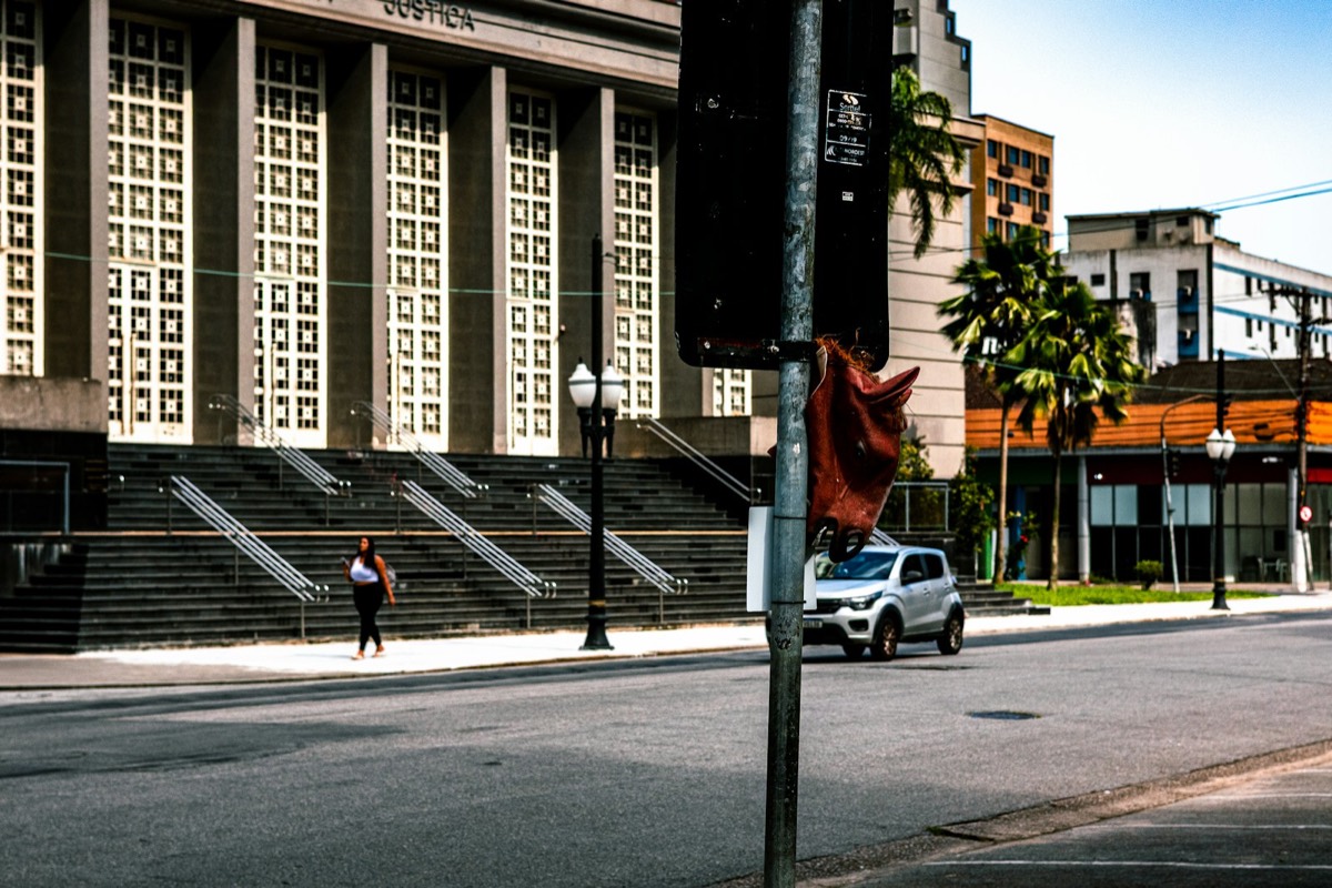 A silver suv drives past a large building with stairs