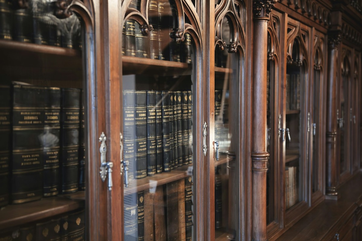 Antique wooden bookshelves filled with leather-bound books