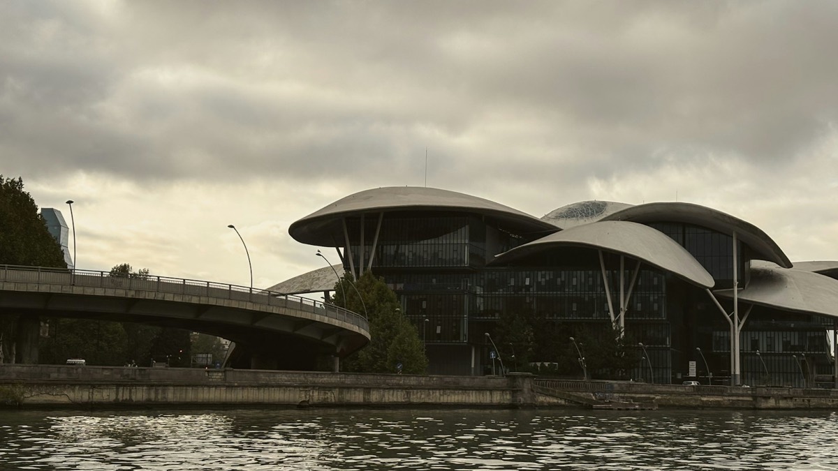 Modern building with mushroom-shaped roofs by river