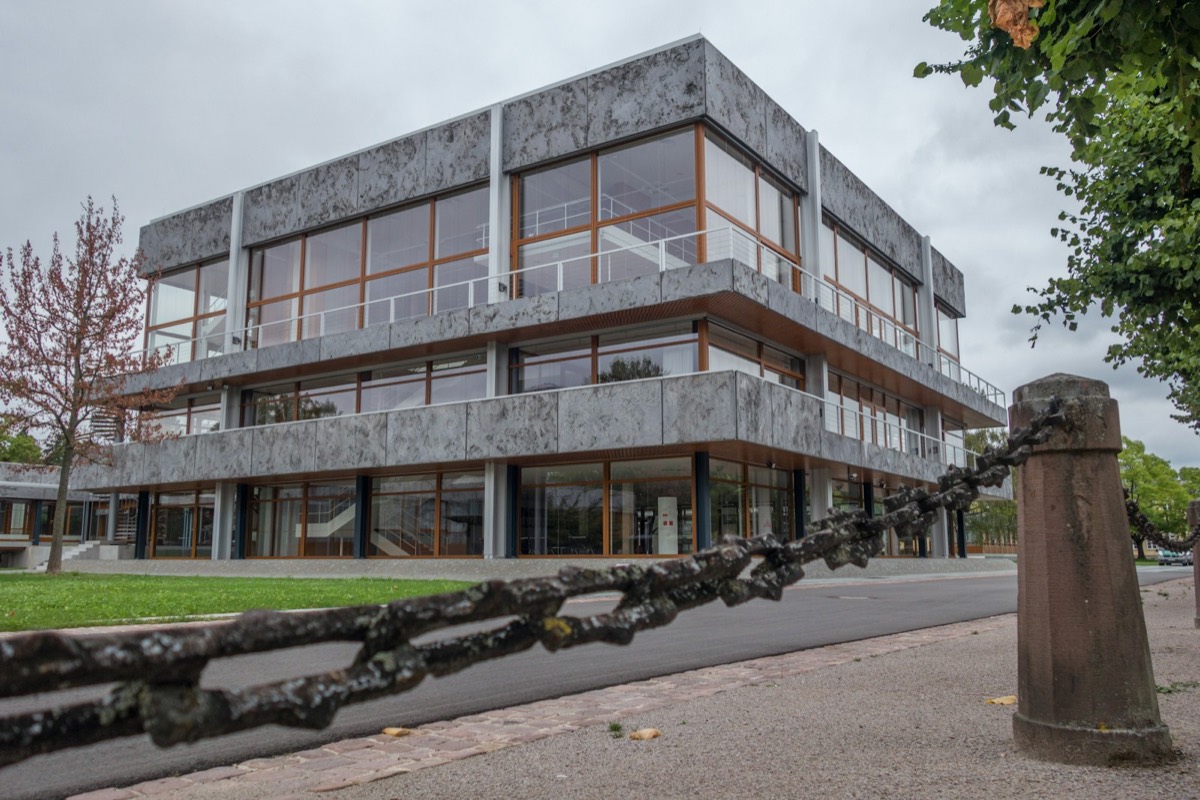 Modern concrete building with large windows and a chain fence