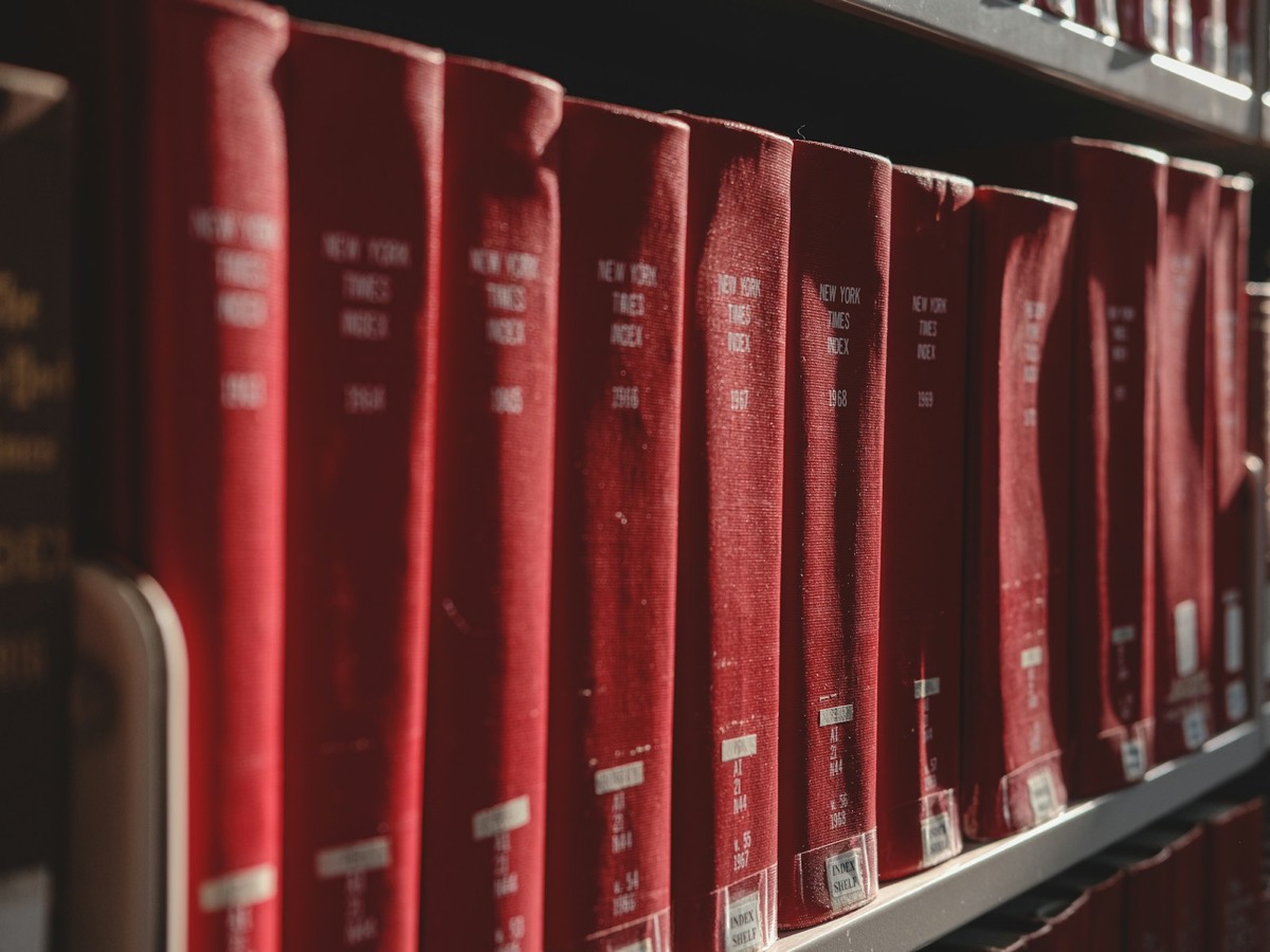 Red books stand on a shelf in the library