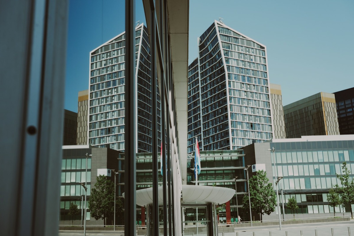 Skyscrapers reflected in a building's glass facade under clear sky