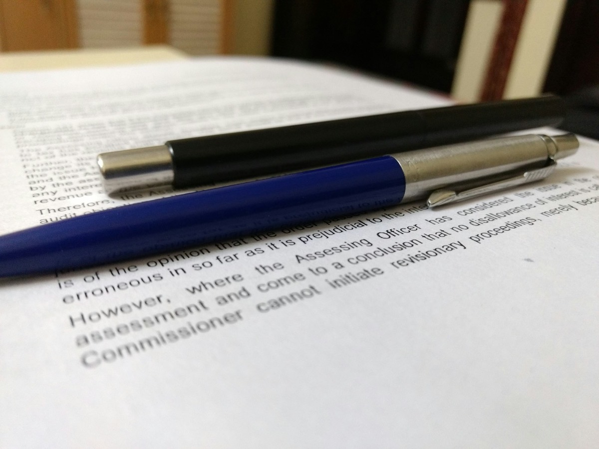 Two black and blue click pens on white book page
