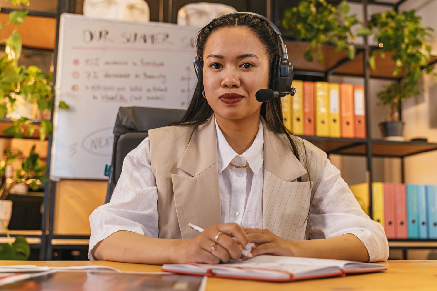 Woman wearing a headset smiling while working at a desk